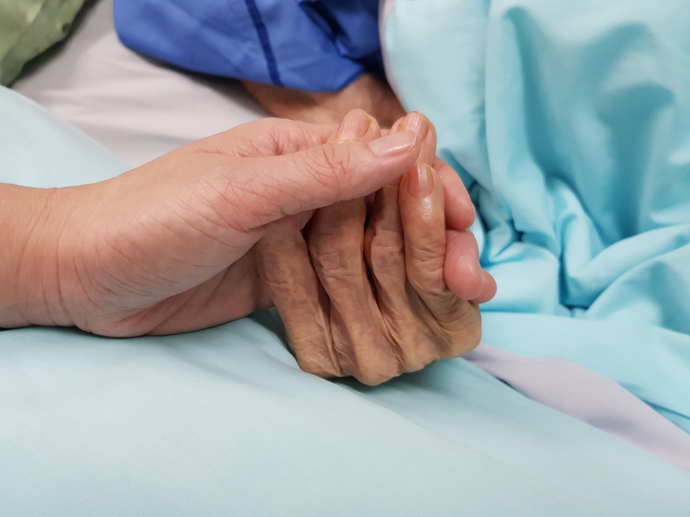 person holding loved one's hand during end of life care at home in Warwickshire
