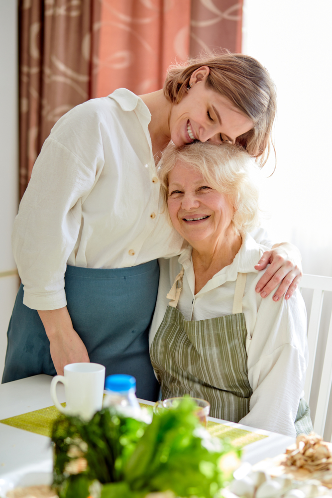 Happy elderly woman and her caregiver sharing a moment of compassion